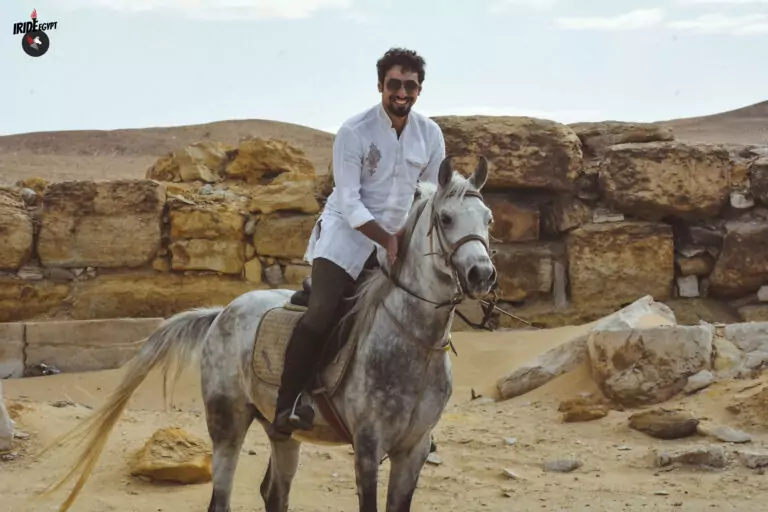 Rider on a grey Arabian horse among the ruins of Saqqara