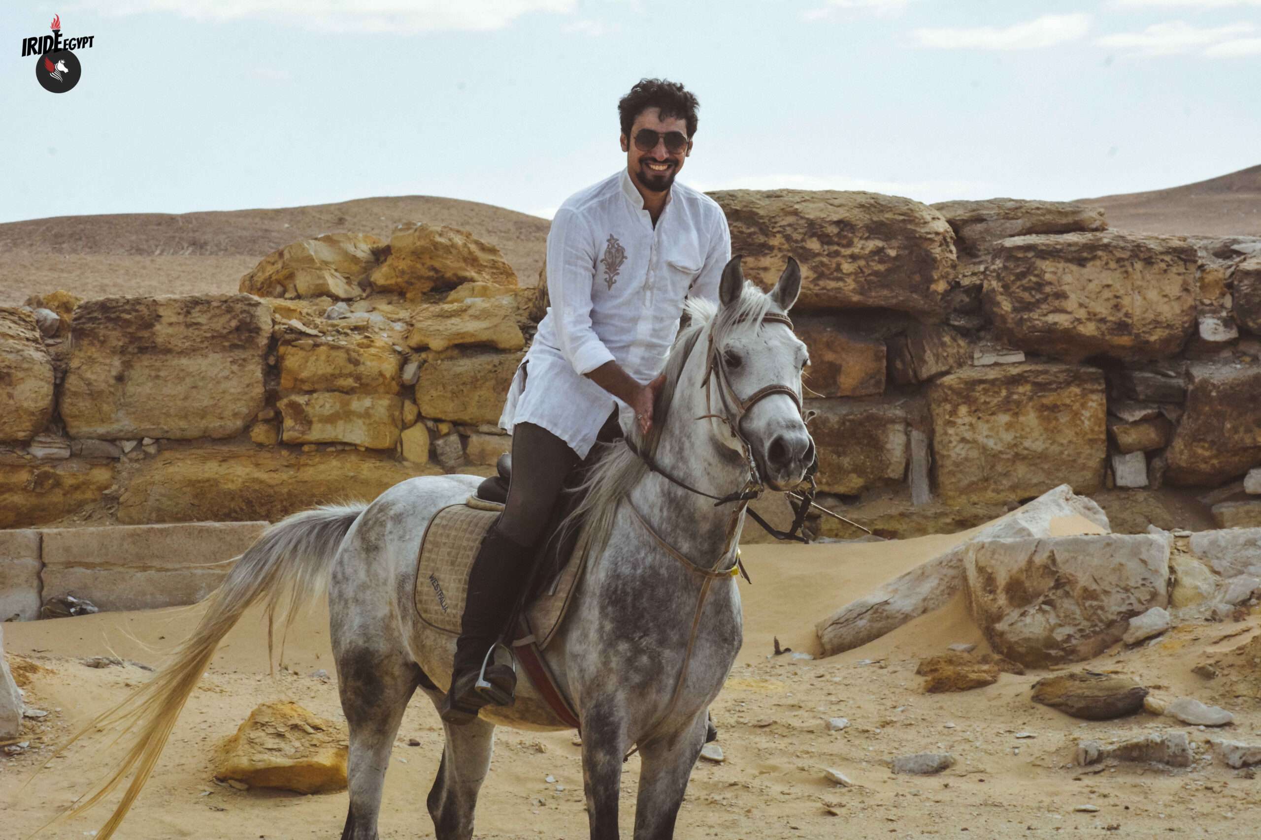 Rider on a grey Arabian horse among the ruins of Saqqara