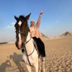 Rider waving on horseback in the Saqqara desert
