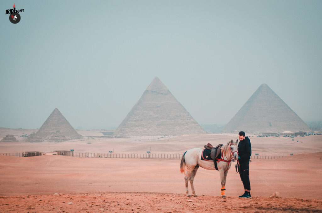 Horse and guide with the three Pyramids of Giza behind