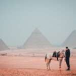 Horse and guide with the three Pyramids of Giza behind