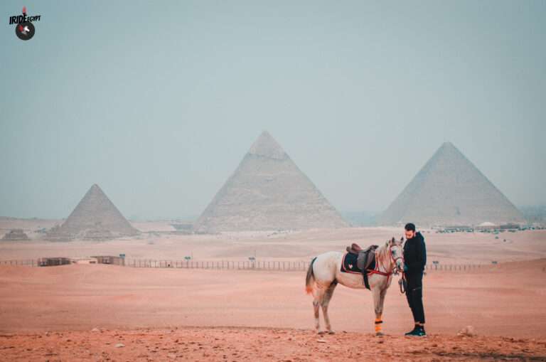 Horse and guide with the three Pyramids of Giza behind