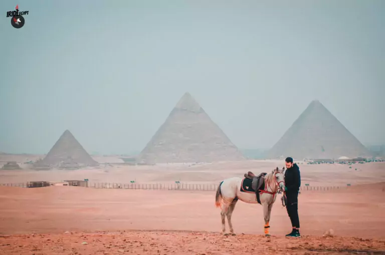 Horse and guide with the three Pyramids of Giza behind