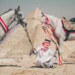 Guide with two white Arabian horses at the Pyramids